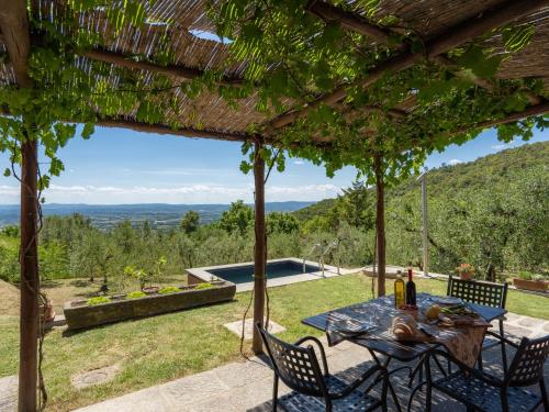 een patio met een tafel en stoelen en een zwembad bij Holiday Home Nido del Sorbino by Interhome in Fondaccio