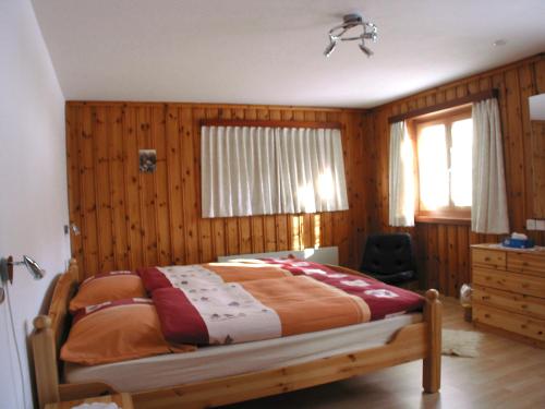 Un dormitorio con una cama con paredes de madera y una ventana en Apartment Tanno by Interhome, en Alvaschein