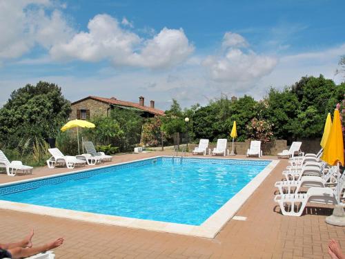 a swimming pool with chairs and umbrellas at Apartment Paradiso Selvaggio-1 by Interhome in Paciano