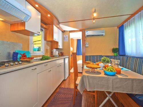 uma cozinha rv com uma mesa com fruta em Holiday Home Maxi Caravan Escale by Interhome em Baia Domizia