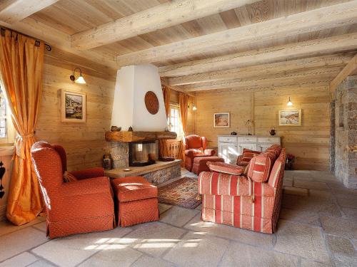 un soggiorno con divani e camino di Chalet Chalet Anna by Interhome a Grosotto