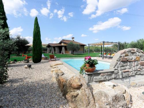 a swimming pool in a yard with a rock wall at Villa Cipresso by Interhome in Sutri