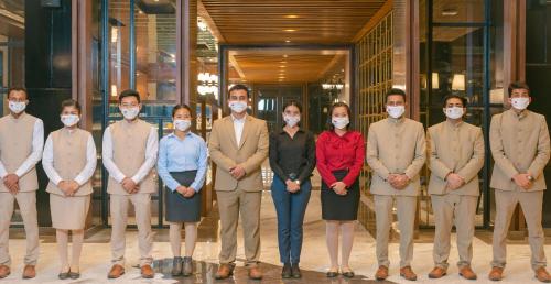 a group of people wearing masks in front of a building at Hotel Polo Towers Agartala in Agartala
