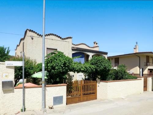 a house with a fence and an umbrella at Holiday Home Lia by Interhome in La Caletta