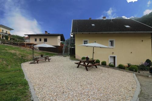 two picnic tables with umbrellas next to a building at Zirnberg Appartements in Flattach