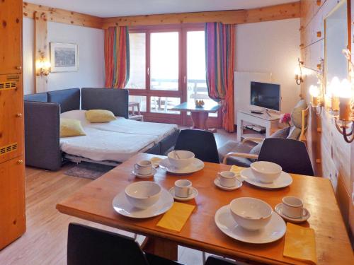 a living room with a table with dishes on it at Apartment Le Bristol A54 by Interhome in Villars-sur-Ollon