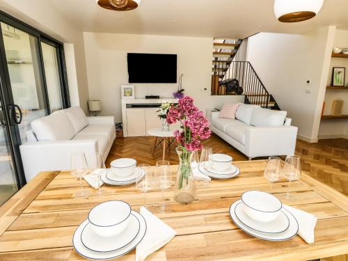 a living room with a table with plates and flowers at Aquanaut in Cowes