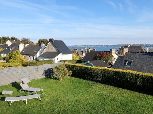 une cour avec deux chaises blanches sur l'herbe dans l'établissement Holiday Home l'Hermine by Interhome, à Ploubazlanec
