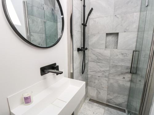a bathroom with a shower and a sink and a mirror at Aquanaut in Cowes
