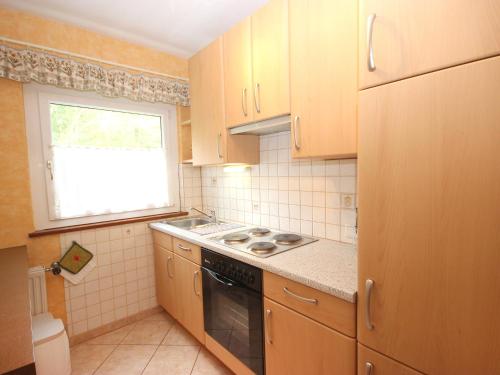 a small kitchen with a stove and a window at Apartment Am Birkenhain-6 by Interhome in Seefeld in Tirol