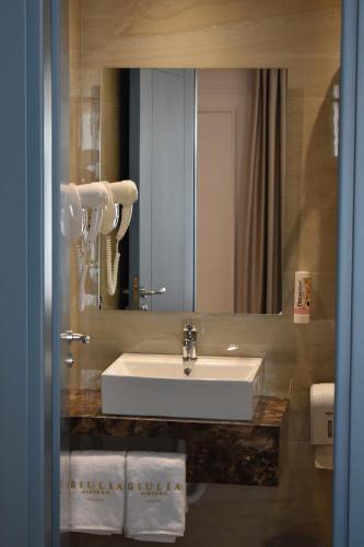 y baño con lavabo blanco y espejo. en Giulia Albérgo Hotel en Durrës
