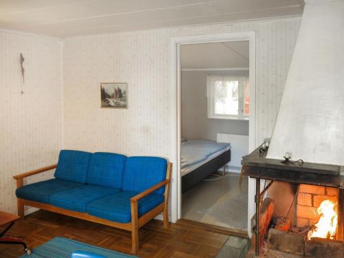 ein Wohnzimmer mit einem blauen Sofa und einem Kamin in der Unterkunft Chalet Älgnäs - HSL040 by Interhome in Stråtjära