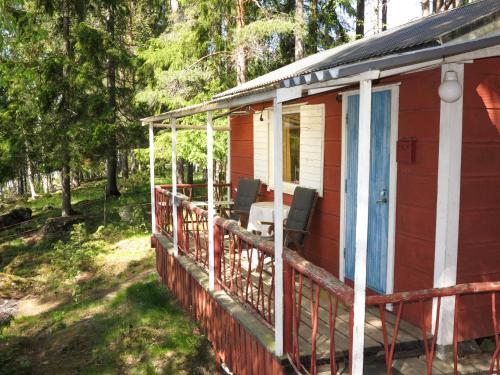 ein rotes Haus mit einer Veranda mit Stühlen darauf in der Unterkunft Chalet Älgnäs - HSL040 by Interhome in Stråtjära