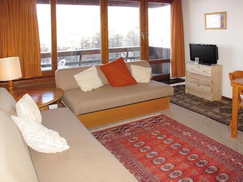 ein Wohnzimmer mit einem Sofa und einem TV in der Unterkunft Apartment Résidence Dixence-15 by Interhome in Les Collons