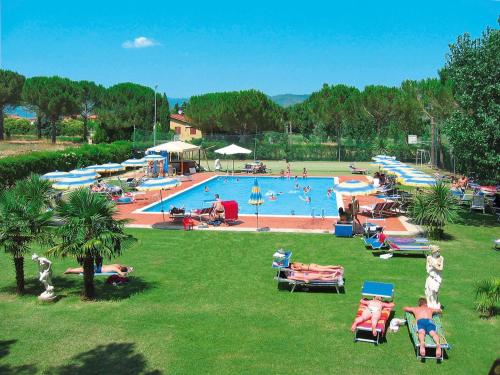 a large swimming pool with people sitting on lawn chairs at Holiday Home Camping Badiaccia-1 by Interhome in Borghetto