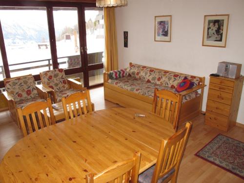ein Wohnzimmer mit einem Holztisch und einem Sofa in der Unterkunft Apartment Résidence Essert-25 by Interhome in Les Collons
