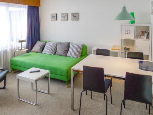a living room with a green couch and a table at Apartment Ringstrasse - Utoring-6 by Interhome in Leukerbad