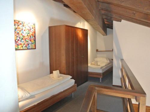a room with two beds and a wooden cabinet at Apartment Residenza Chesa Margun 46-3 by Interhome in Surlej