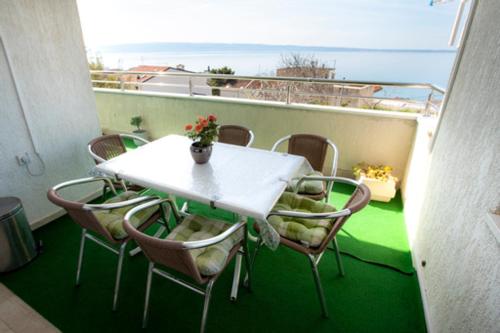 uma mesa branca e cadeiras numa varanda em Beautiful place near the sea em Podstrana