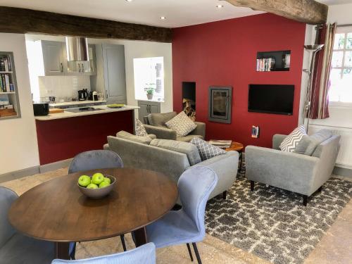 a living room with a table and chairs and a kitchen at Holiday Home The Old Bakery by Interhome in Tonnerre