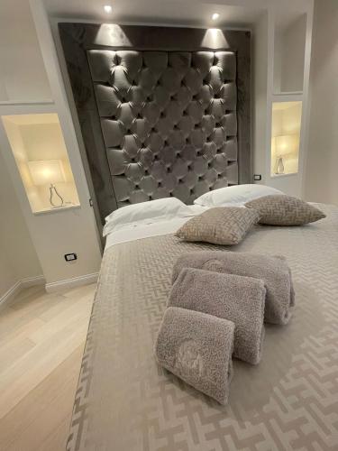 a bedroom with a large bed with a large headboard at Minori Palace De Luxe Apartment in Minori
