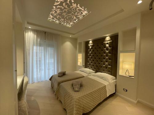 a bedroom with a large bed and a chandelier at Minori Palace De Luxe Apartment in Minori