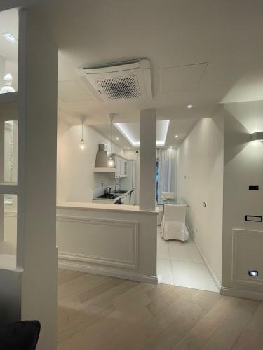 a living room with white walls and a kitchen at Minori Palace De Luxe Apartment in Minori