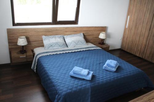 a bedroom with a bed with two towels on it at Villa Flemish in Izgryev