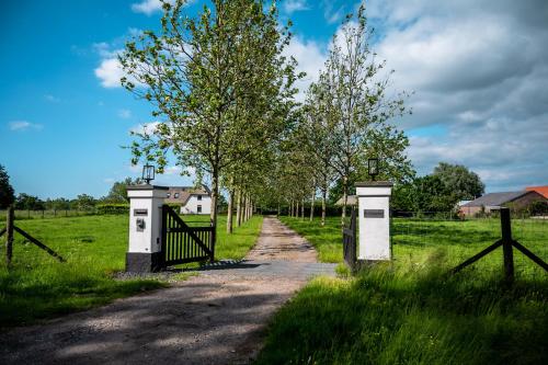 a gate on a dirt road in a field at B&B de Scherpenhof, landelijk gelegen met optie jacuzzi in Leur