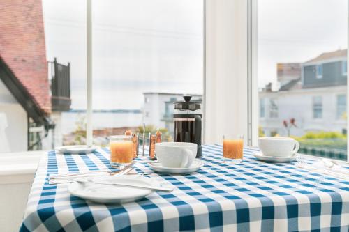 une table avec un chiffon de table bleu et blanc dans l'établissement The Westcott by the Sea - Just for Adults, à Falmouth