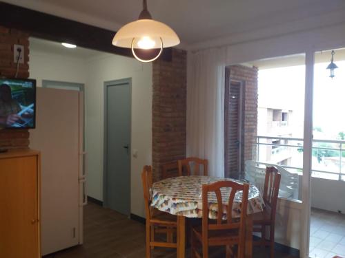 a dining room with a table and chairs and a television at Apartamento vistas al mar de La Pineda in Salou