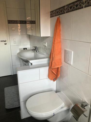 a bathroom with a white toilet and a sink at Ferienwohnung Black Beauty in Wernigerode