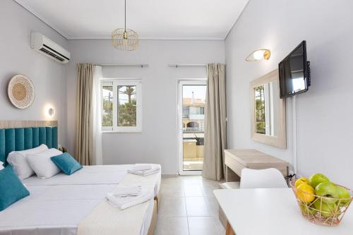 a room with two beds and a tv and a couch at Adele Riva in Adelianos Kampos