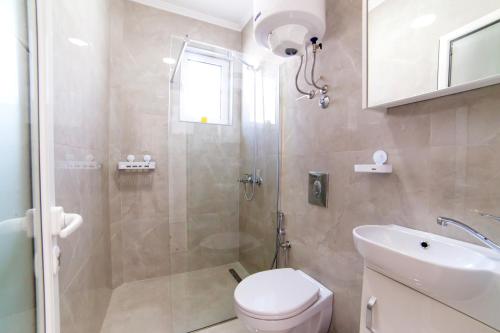 a bathroom with a shower and a toilet and a sink at Apartments Hoxha in Ulcinj