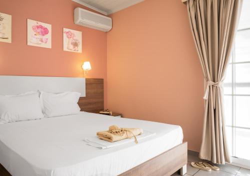 a bedroom with a bed with a towel on it at Ouzas luxury Hotel in Olympiaki Akti