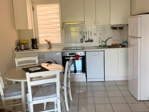 - une cuisine avec une table et des appareils électroménagers blancs dans l'établissement APARTAMENTO HENDAYA Playa-wifi-parking, à Hendaye