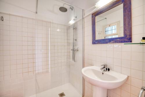 uma casa de banho branca com um lavatório e um espelho em Panoramic Sea Views em Calella de Palafrugell