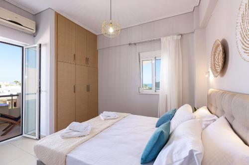 a bedroom with a large white bed with blue pillows at Adele Riva in Adelianos Kampos
