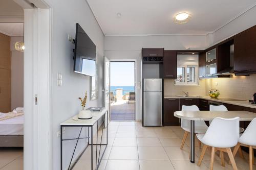 a kitchen and dining room with a view of the ocean at Adele Riva in Adelianos Kampos