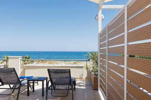 a patio with chairs and a view of the ocean at Adele Riva in Adelianos Kampos