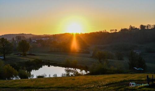 a sunset over a field with a pond at Antiche Vie B&B in Serramazzoni
