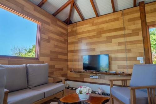 a living room with a couch and a flat screen tv at KALYPSO - Les Villas KIKKO in Saint-François