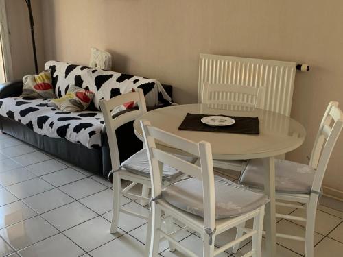 APARTAMENTO HENDAYA Playa-wifi-parking في أُنْداي: طاولة وكراسي في غرفة معيشة مع أريكة