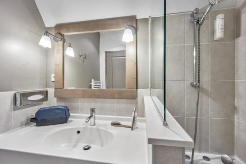 a bathroom with a sink and a shower at Pierre & Vacances Premium Residence & Spa Houlgate in Houlgate