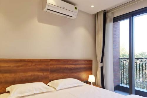 ein Schlafzimmer mit einem großen Bett und einem Balkon in der Unterkunft Apt# ONE-FOUR-TWO - with Lift - High Speed Wifi - Smart TV in Neu-Delhi