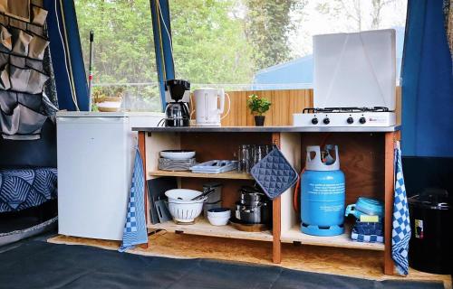 a shelf with a stove in a tent at 4 persoons ingerichte tent op kleine camping in Anna Paulowna