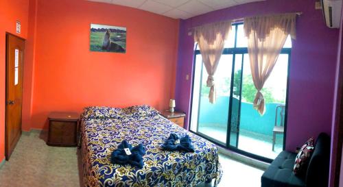 - une chambre avec un lit et une grande fenêtre dans l'établissement La Casa de Jeimy, à Puerto Baquerizo Moreno