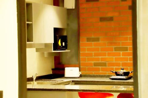 a kitchen with a sink and a counter top at Apt# ONE-FOUR-TWO - with Lift - High Speed Wifi - Smart TV in New Delhi