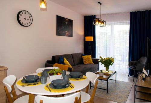 un soggiorno con tavolo e divano di Olympic Apartments Mielno a Mielno