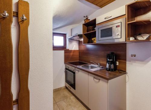 a kitchen with a sink and a microwave at Haus Talblick in Pettneu am Arlberg